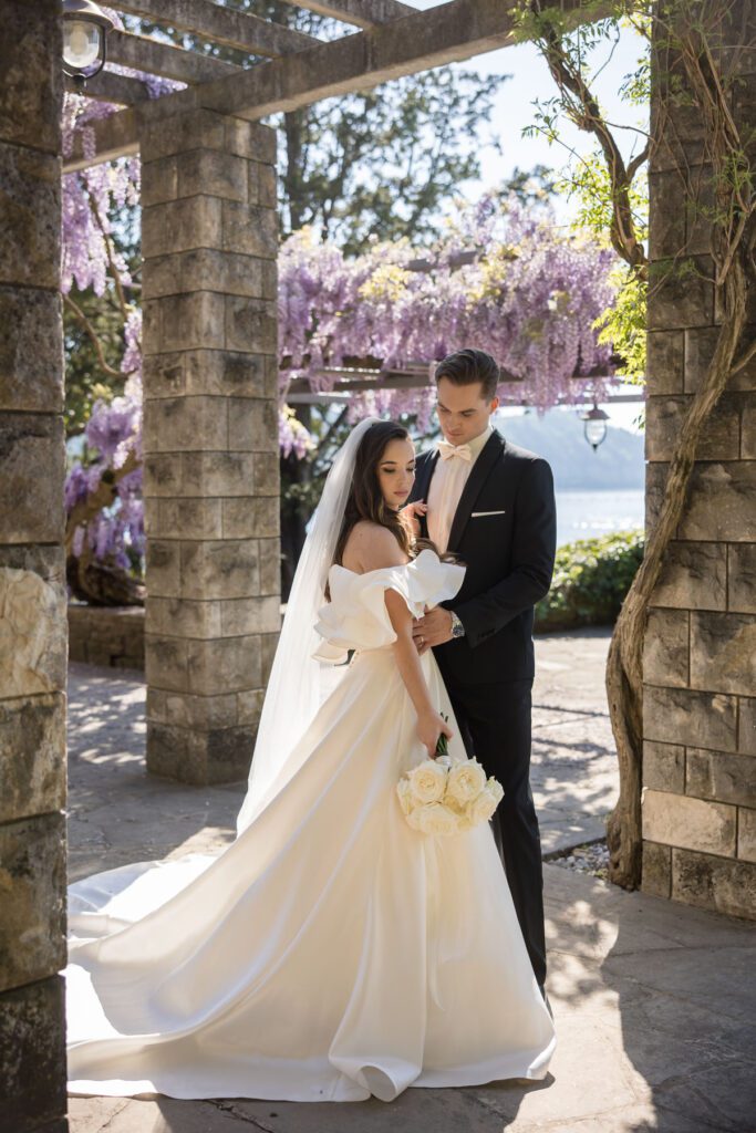 romantic bride and groom under wisteria pergola during destination wedding in Italy