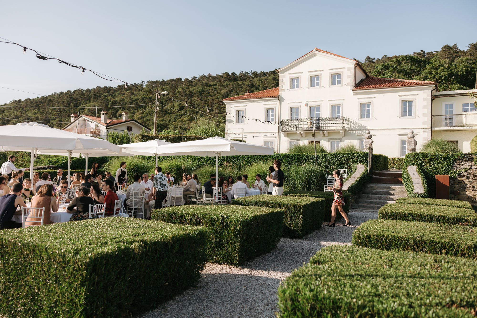 Villa Bonomo wedding reception in Trieste Italy with guests dining in the garden overlooking the Adriatic coast