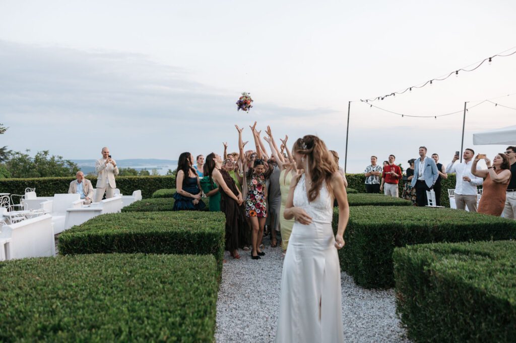 bouquet toss villa bonomo wedding trieste italy bride throwing flowers guests