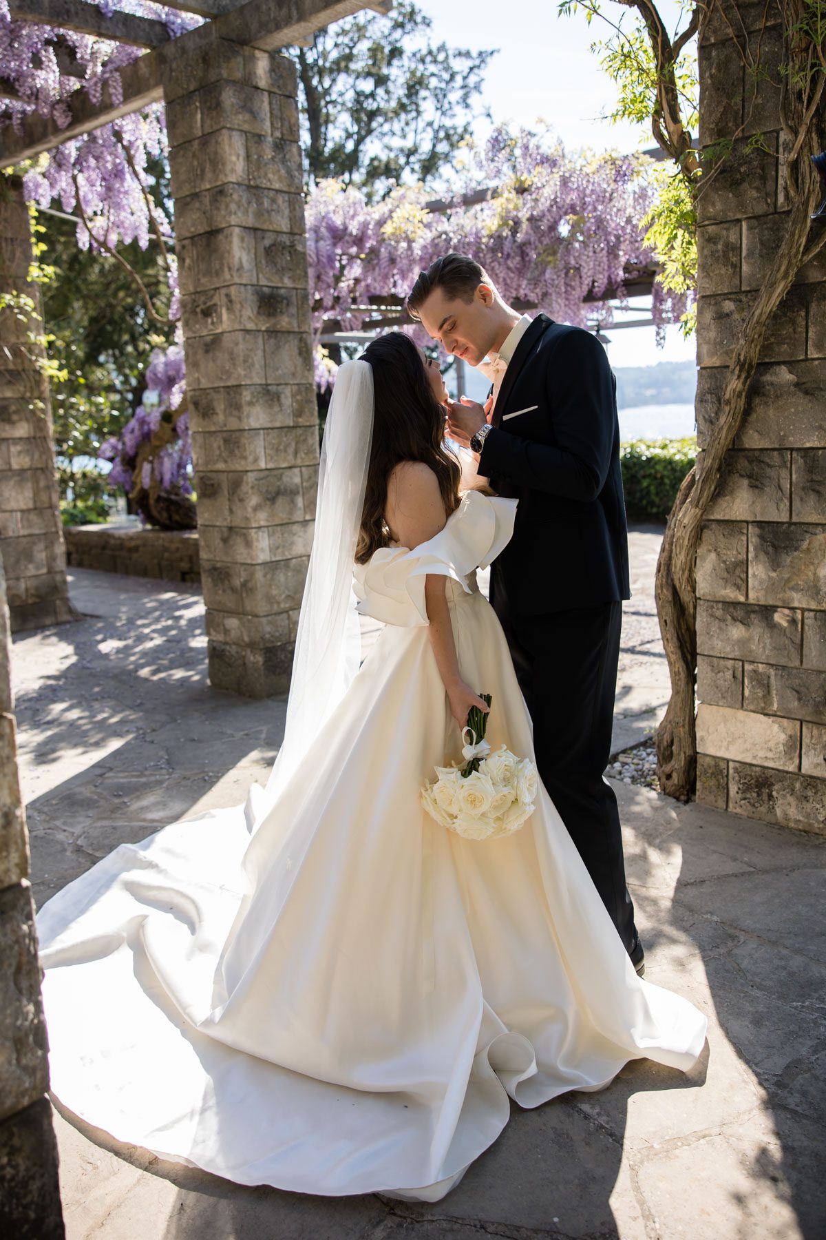 Bride and groom under wisteria pergola at Villa Tartini Strunjan Slovenia romantic wedding moment