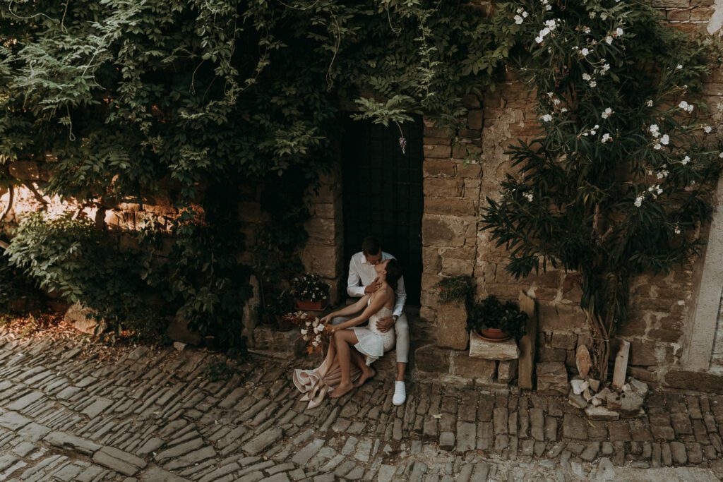 romantic couple sitting in a stone alley in Croatia during an intimate destination wedding