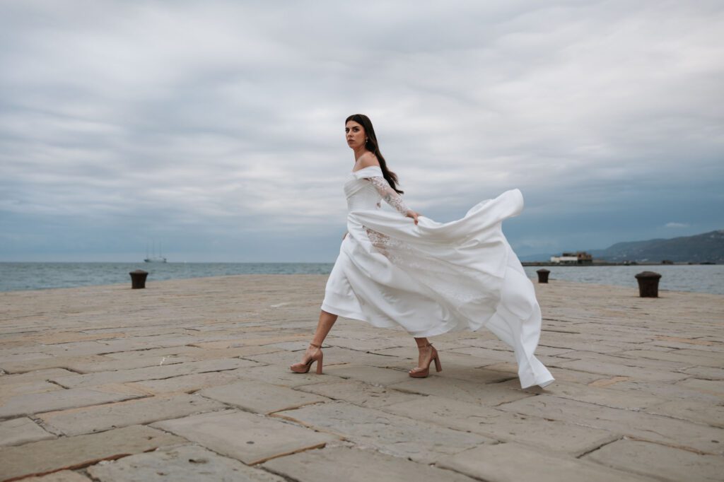 Bride walking by the sea in Trieste Italy destination wedding photography Adriatic coast