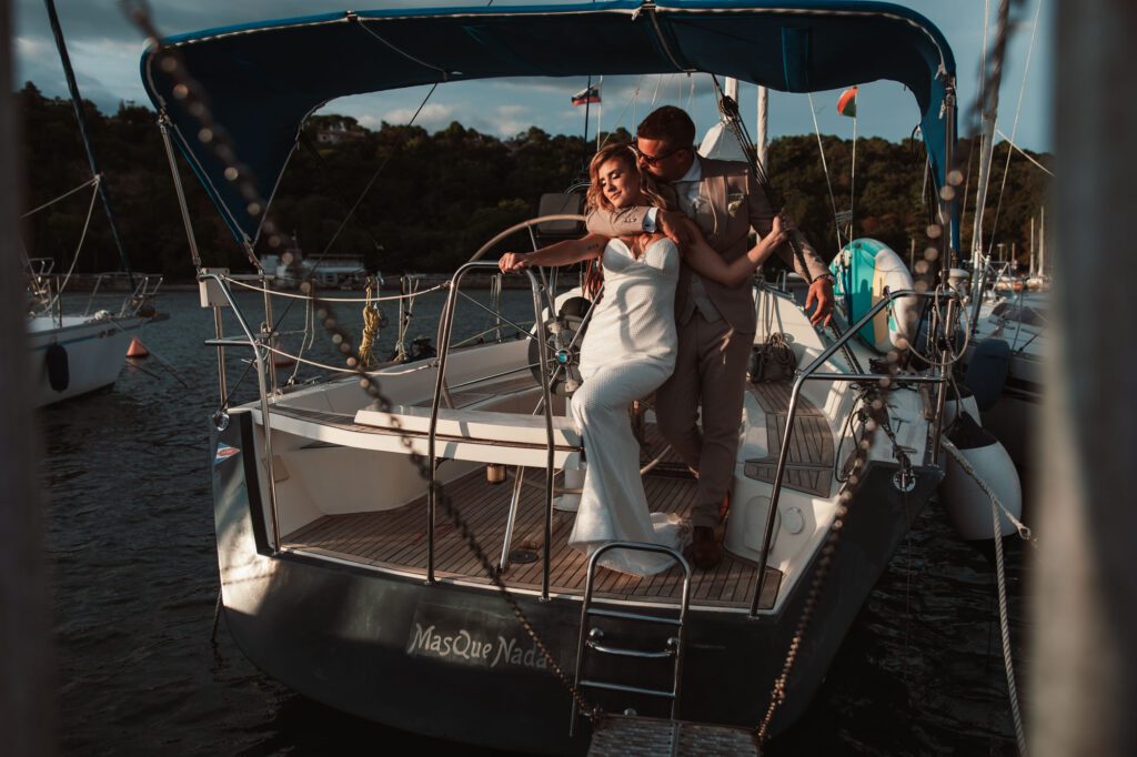 Luxury wedding couple on a yacht in Portopiccolo Sistiana Italy during golden hour with intimate embrace