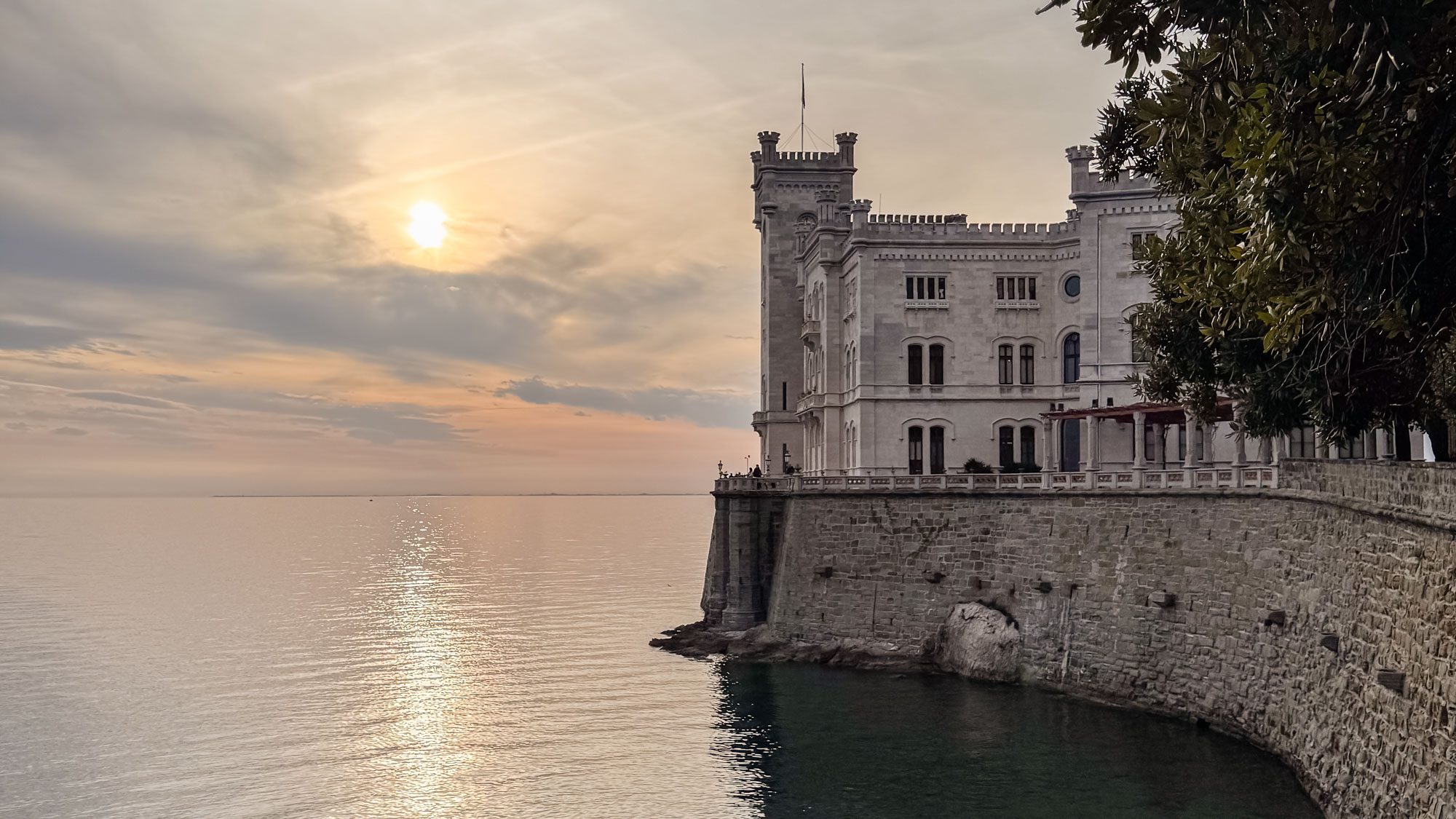 Miramare Castle in Trieste, Italy overlooking the Adriatic Sea at sunset, a romantic seaside wedding venue