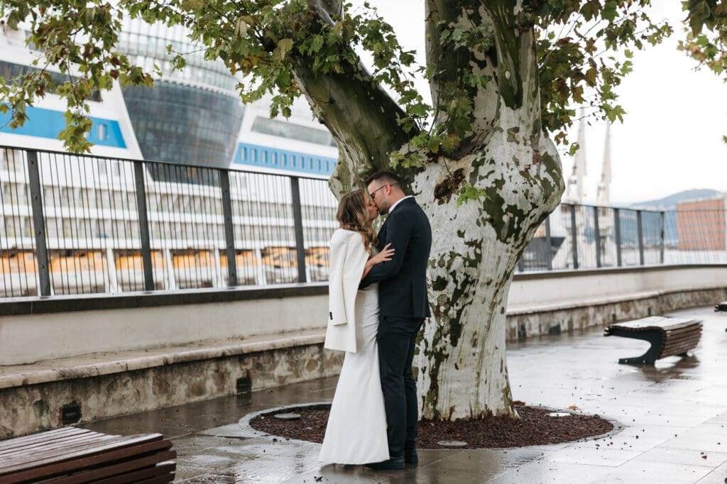 Bride and groom sharing a quiet first look moment by the waterfront in Koper, Slovenia on a rainy wedding day.