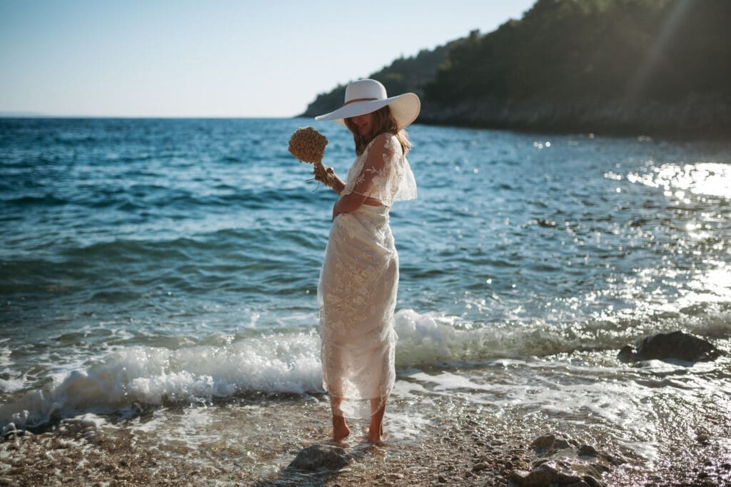 Bride holding a dried immortelle bouquet during an intimate Hvar elopement at Jedra Bay on Hvar island, Croatia