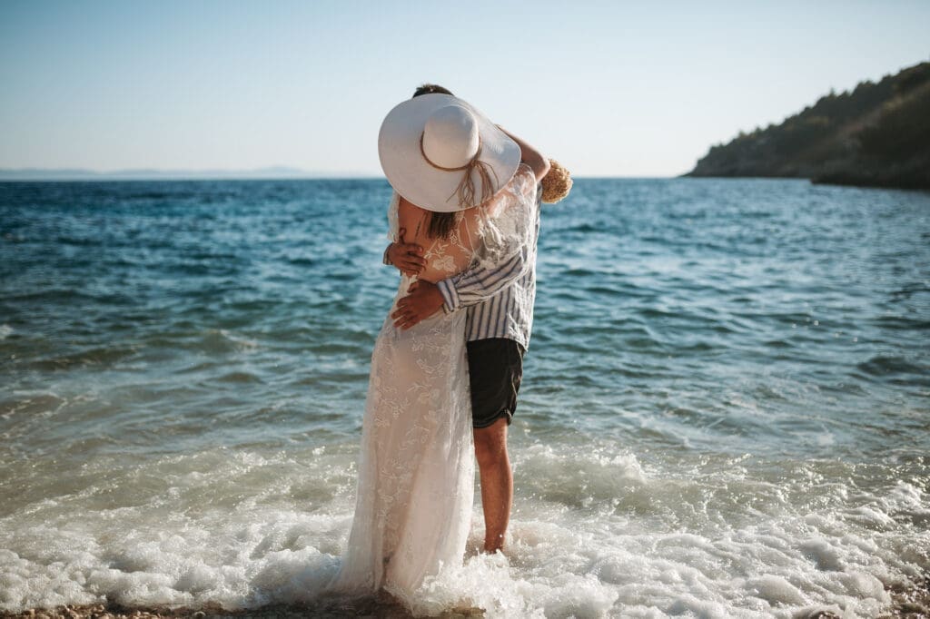 Couple embracing in the sea during private vows at Jedra Bay, a hidden Hvar bay for an intimate Croatia elopement