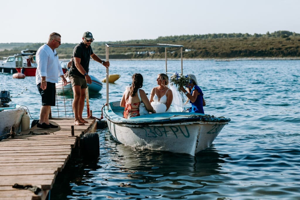 Bride arriving by small boat for a beach wedding ceremony on Levan Island in Croatia surrounded by the Adriatic Sea and summer light.