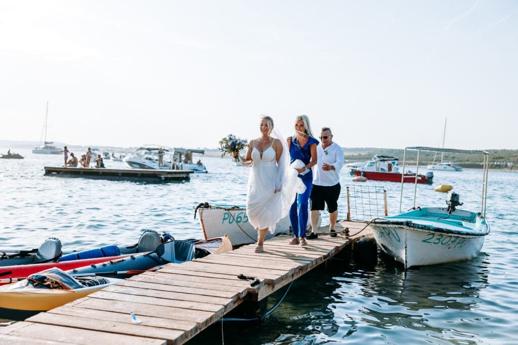Bride arriving at Levan Island by boat before her intimate beach wedding ceremony in Croatia on a sunny Adriatic summer day.