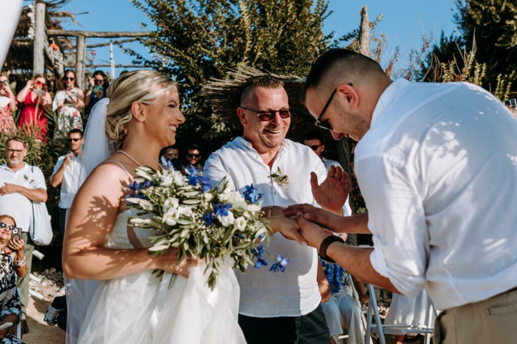 Bride and groom sharing an emotional moment with the bride’s father during a beach wedding ceremony on Levan Island in Croatia.