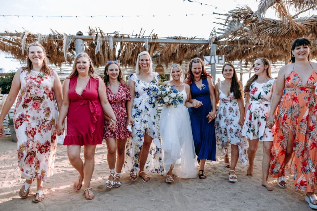 Bride walking on the beach with her bridesmaids after an intimate wedding ceremony on Levan Island in Croatia during a relaxed summer celebration.