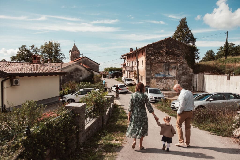 Wedding guests walking through Šmihelj toward the Church of St. Michael during Zala and Matej's wedding day in Slovenia.