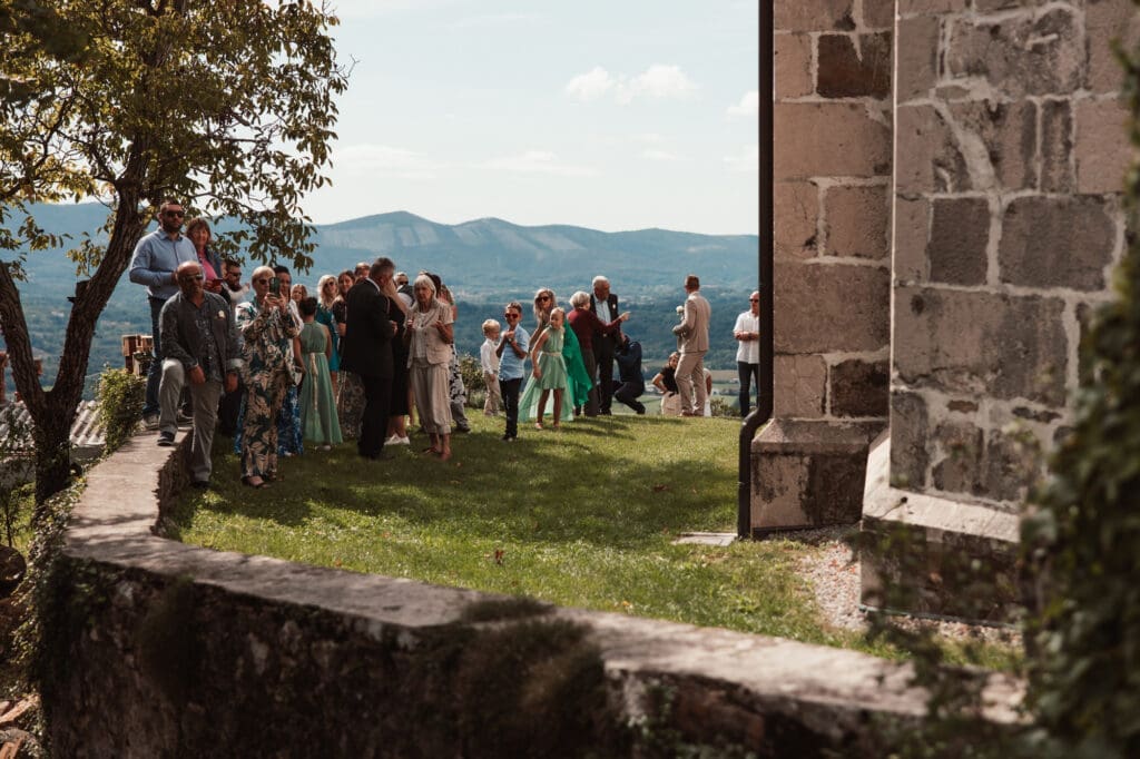 Wedding guests gathered outside the Church of St. Michael in Šmihelj during Zala and Matej's ceremony in Slovenia.
