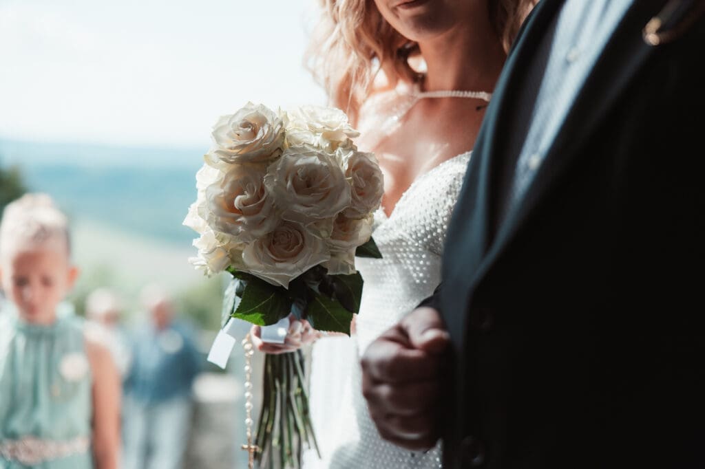 White bridal bouquet and wedding dress details during Zala and Matej's wedding day.