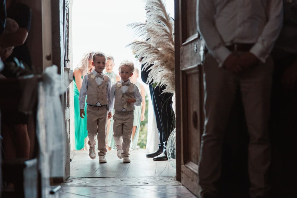 Children walking into the Church of St. Michael in Šmihelj before Zala and Matej's wedding ceremony in Slovenia.