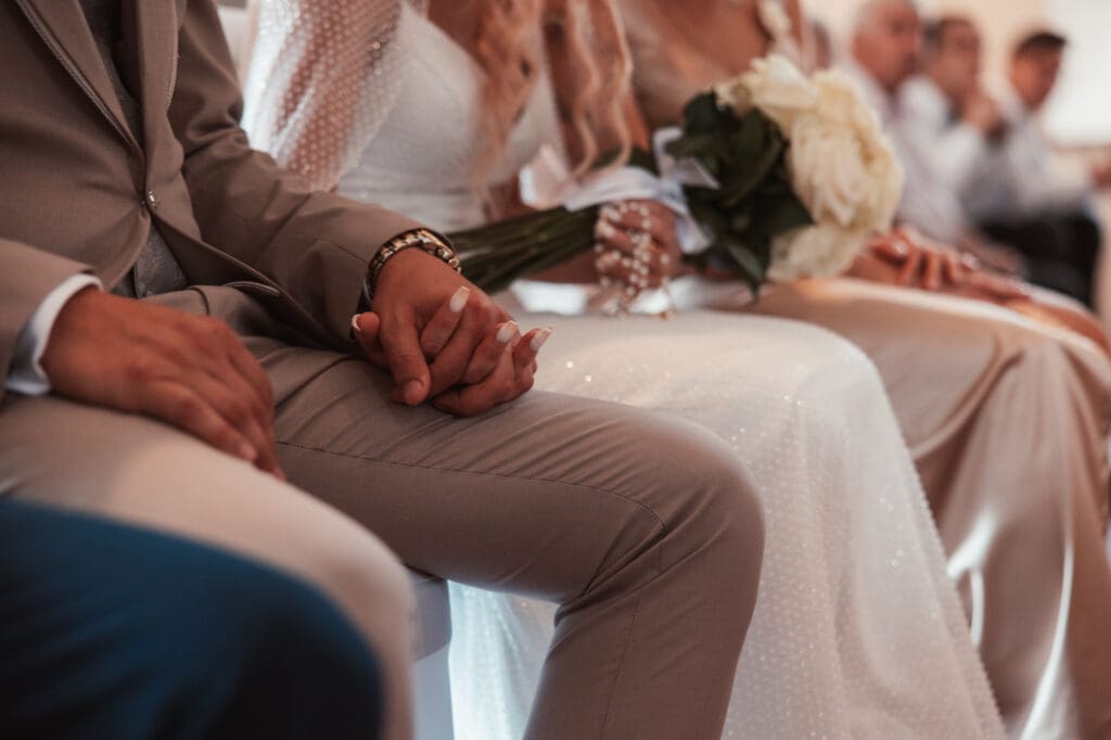 Zala and Matej holding hands during their wedding ceremony at the Church of St. Michael in Šmihelj.