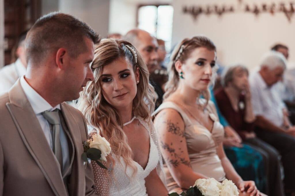 Zala and Matej sharing a quiet moment during their wedding ceremony at the Church of St. Michael in Šmihelj.