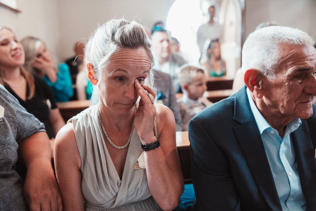 Zala's mother becoming emotional during her daughter's wedding ceremony at the Church of St. Michael in Šmihelj.