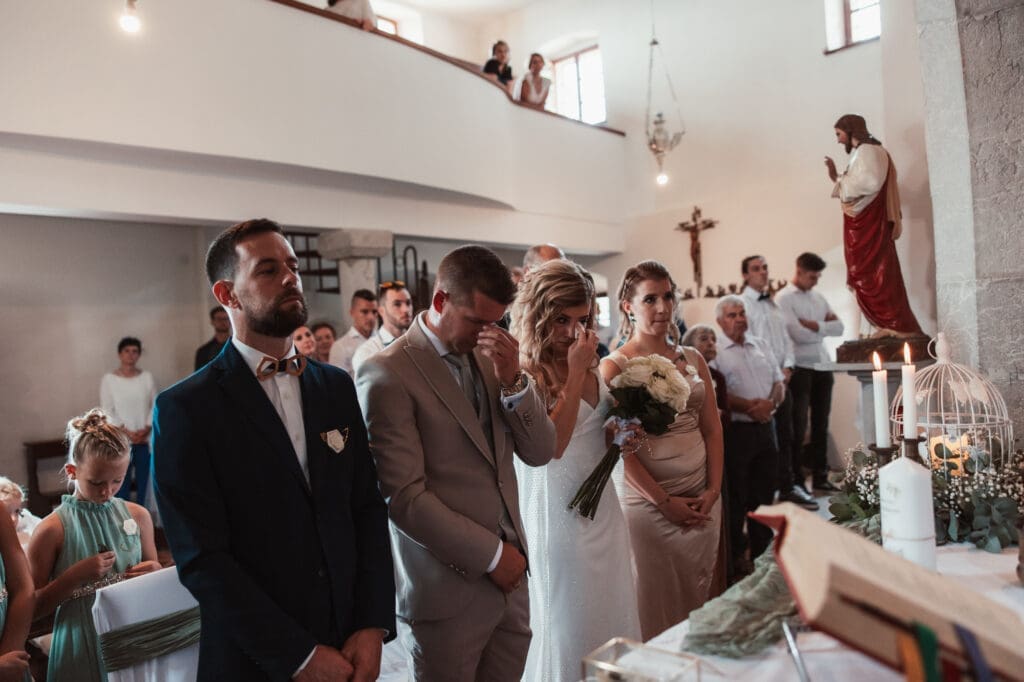 Zala and Matej sharing an emotional moment during their church wedding ceremony in Šmihelj, Slovenia.