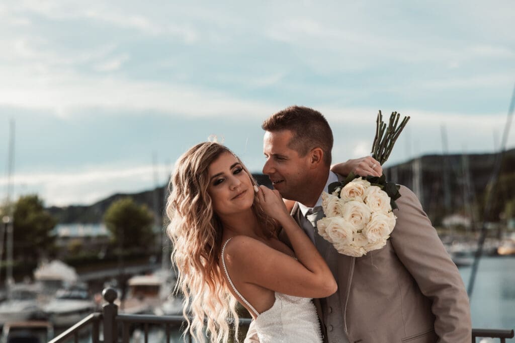 Zala and Matej embracing during romantic wedding portraits in Portopiccolo overlooking the Adriatic marina in Italy.