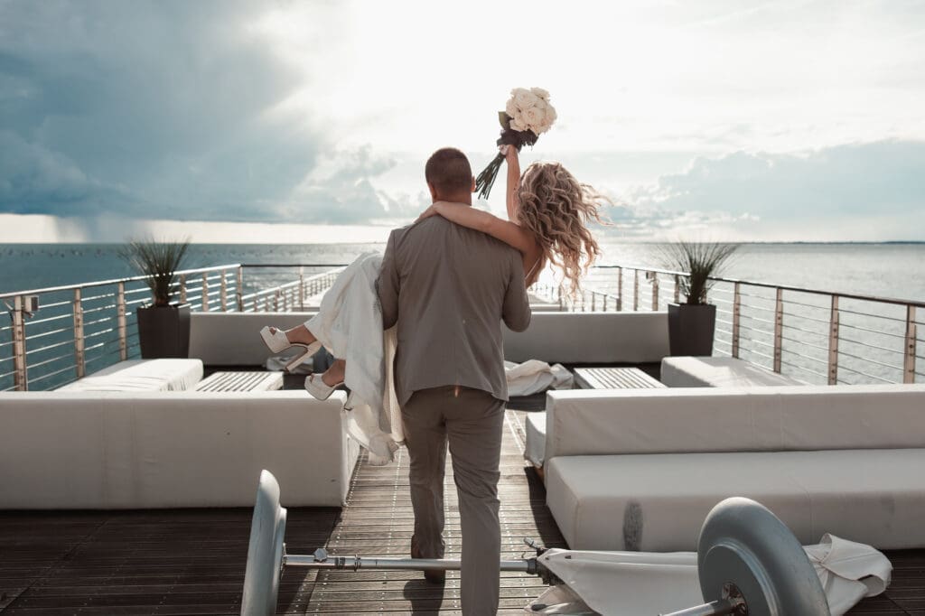 Matej carrying Zala during romantic wedding portraits in Portopiccolo overlooking the Adriatic coast in Italy.