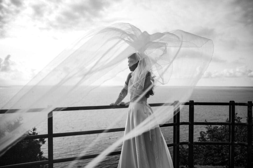 Bride with flowing veil overlooking the Adriatic Sea at a scenic wedding photography location near Trieste, Italy
