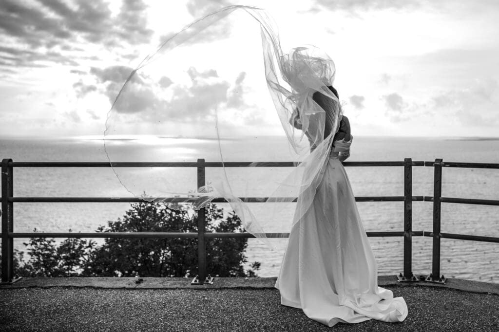 Elegant bridal portrait with a windblown veil overlooking the Adriatic coastline near Trieste, Italy