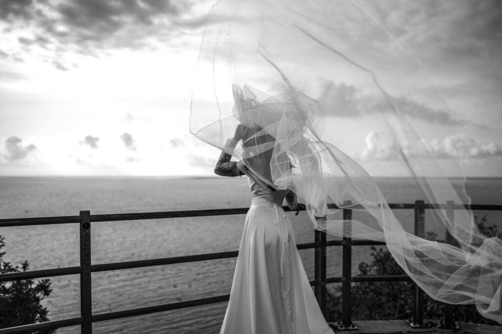 Bride with flowing veil overlooking the Adriatic Sea near Trieste, Italy