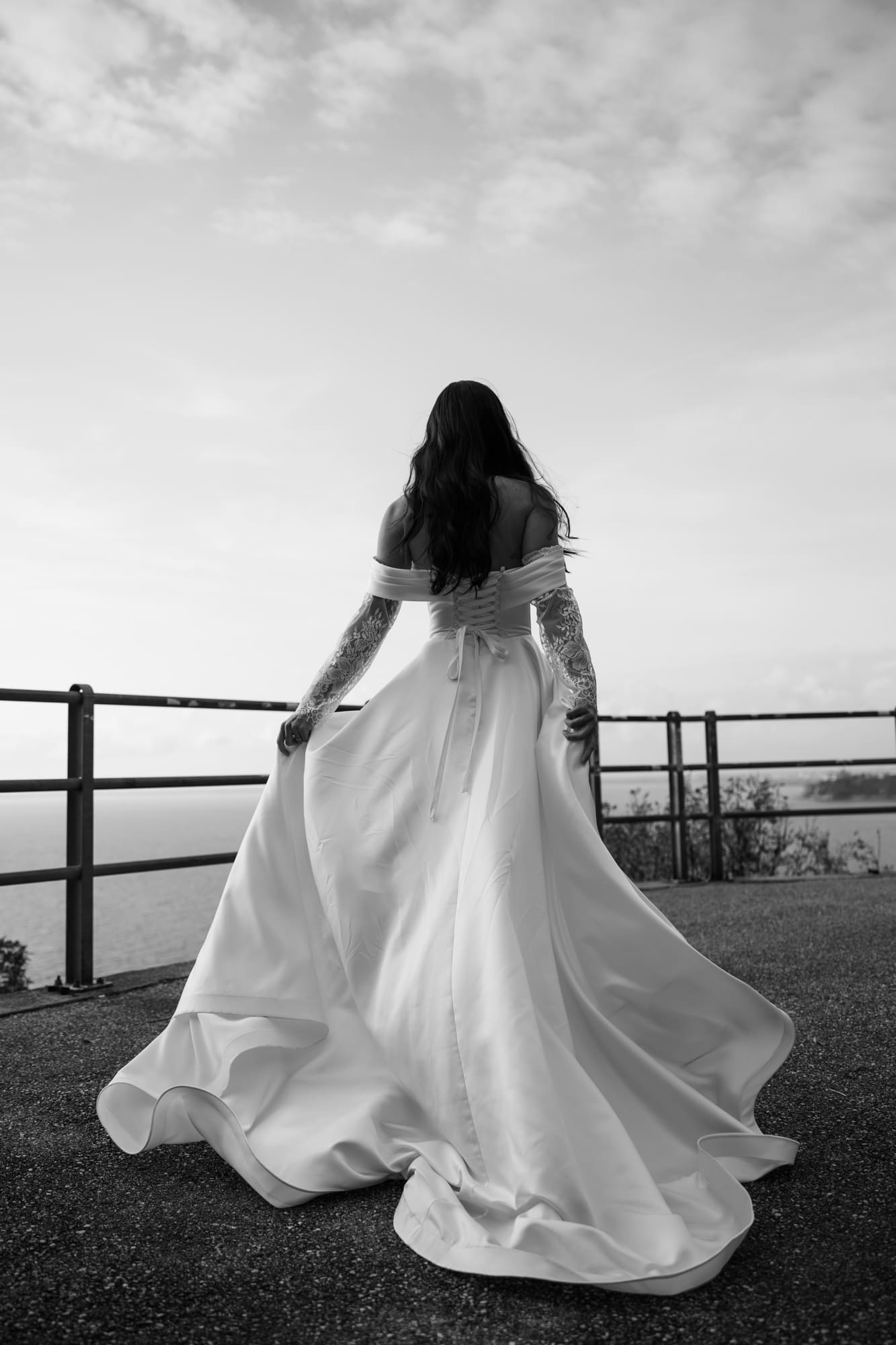 Bride in elegant wedding dress overlooking the Adriatic Sea near Trieste, Italy during a romantic wedding photoshoot