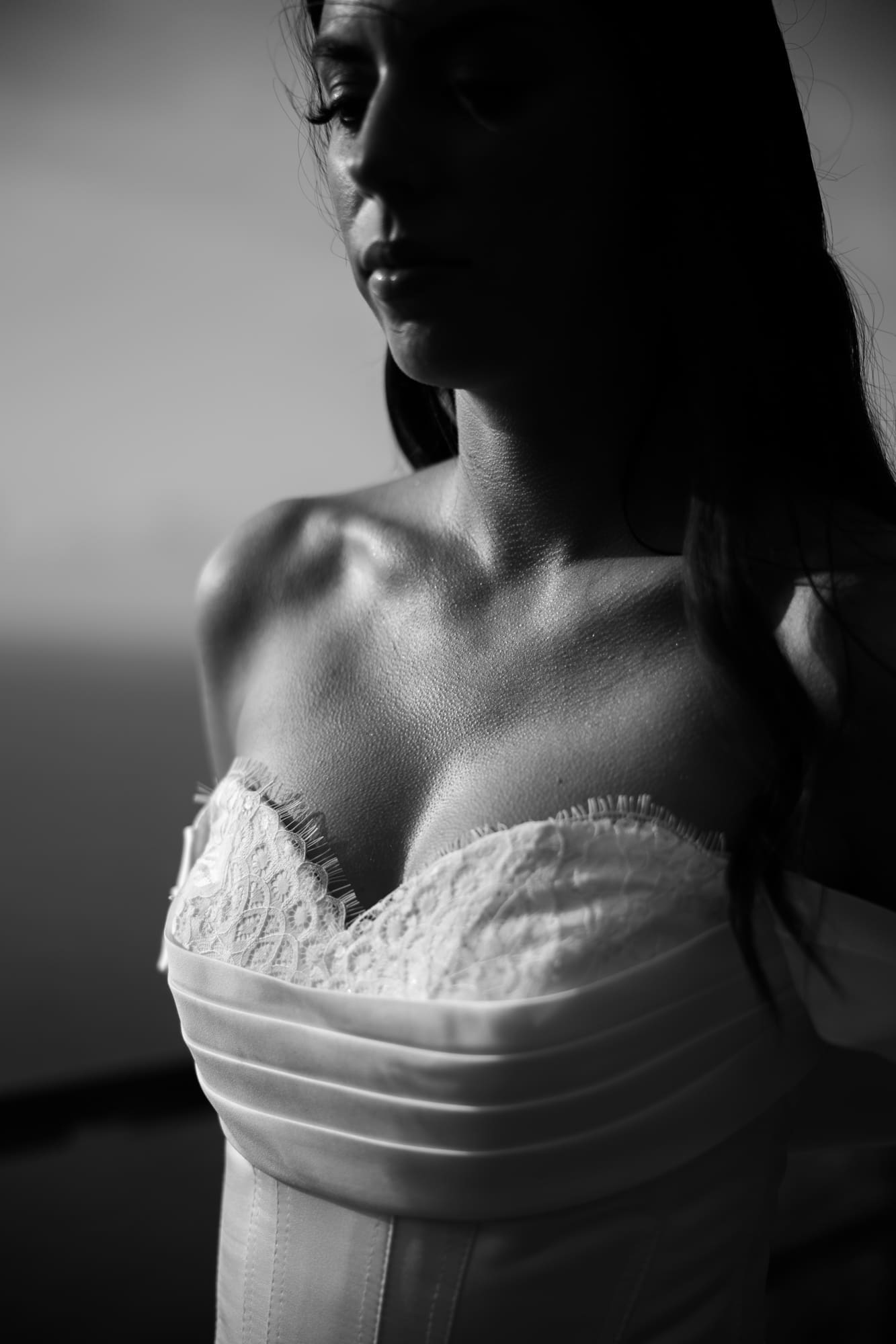 Artistic black and white bridal portrait highlighting the elegant lace wedding dress during a photoshoot near Trieste, Italy