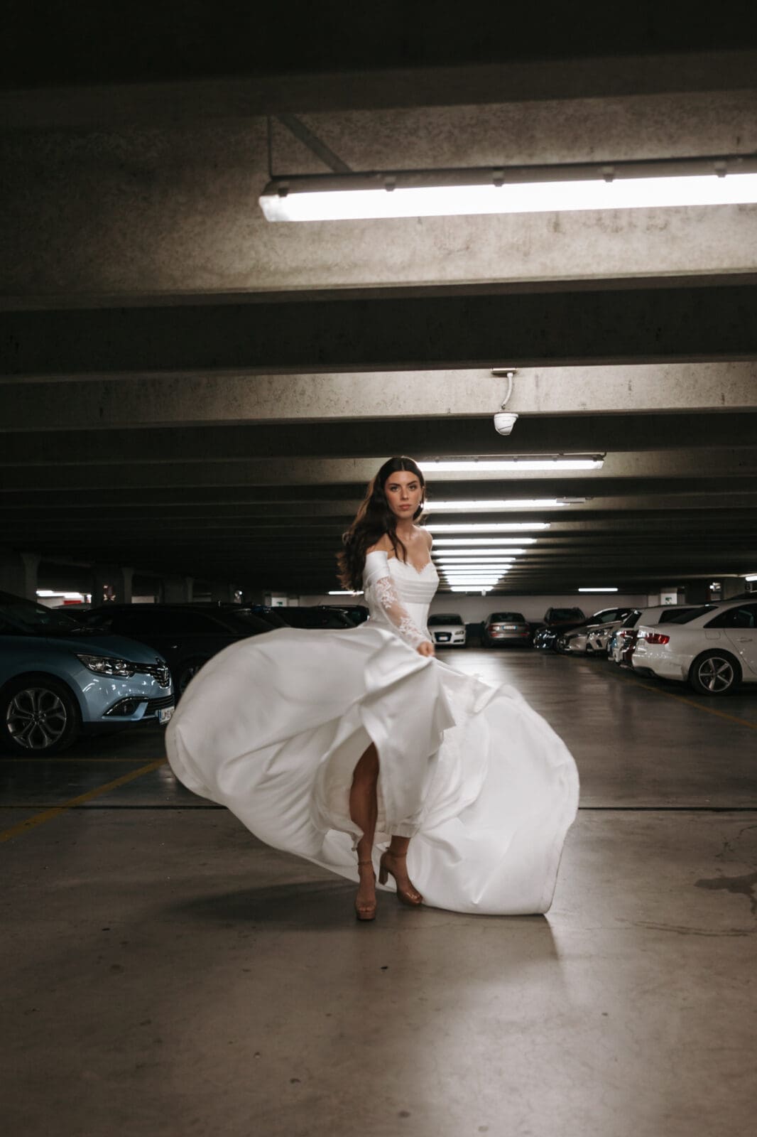 Bride twirling in the Silos parking structure during a contemporary urban wedding photoshoot in Trieste, Italy