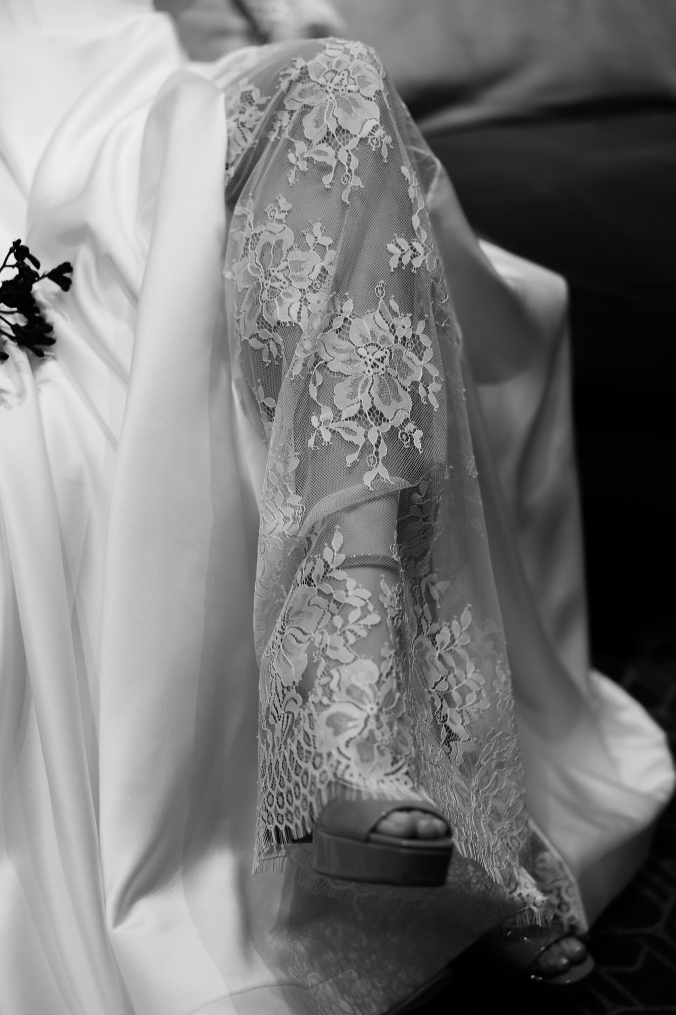 Close-up of a lace wedding dress and bridal heels at The Modernist Hotel during an editorial wedding photoshoot in Trieste, Italy