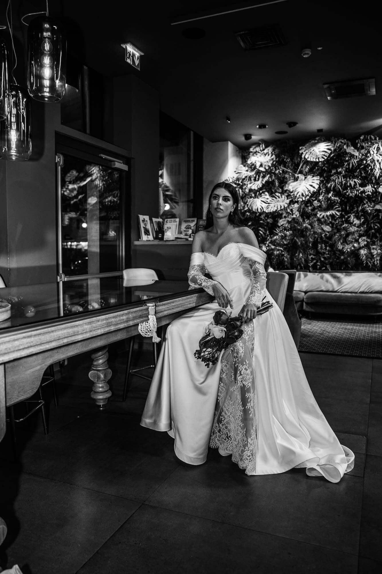 Bride posing beside a vintage billiard table at The Modernist Hotel on Corso Italia during an editorial wedding photoshoot in Trieste, Italy