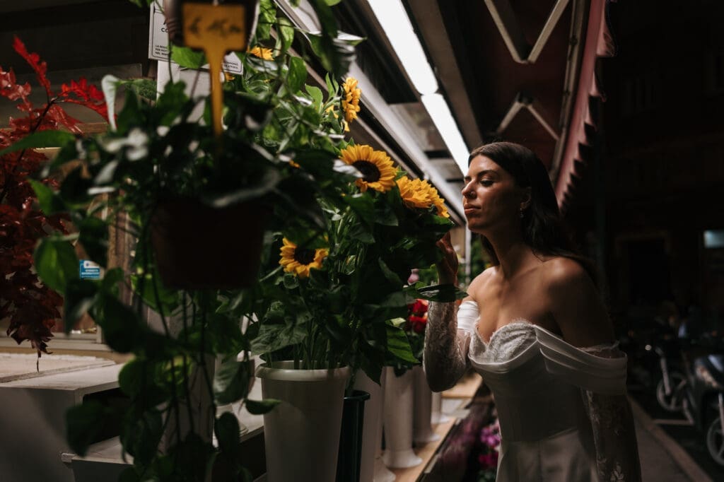 Bride walking past a flower shop in downtown Trieste during an editorial wedding photoshoot in Italy
