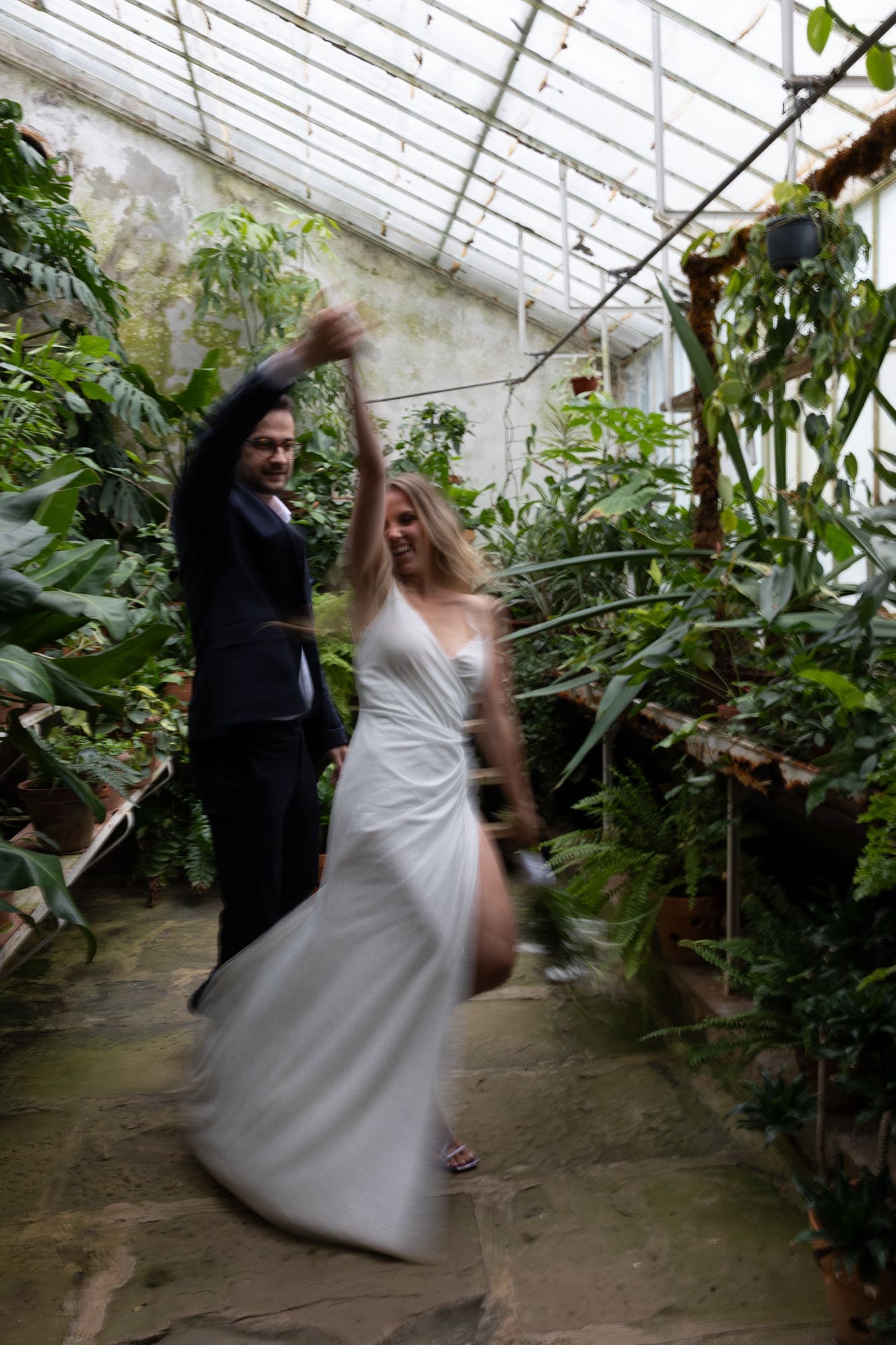 Bride twirling beneath the glass roof of the historic greenhouse at Villa Mirasasso near Sežana, Slovenia.