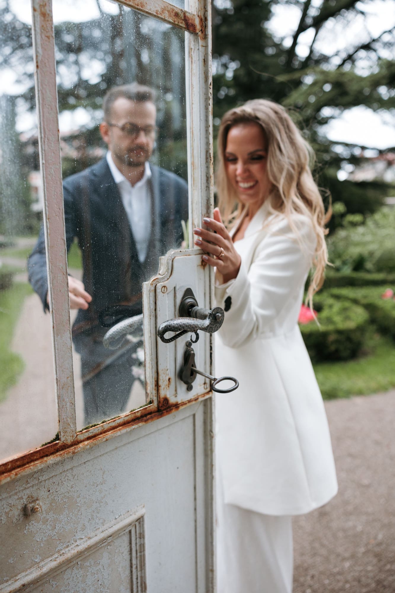 Bride opening the historic greenhouse doors at Villa Mirasasso wedding venue in Slovenia.