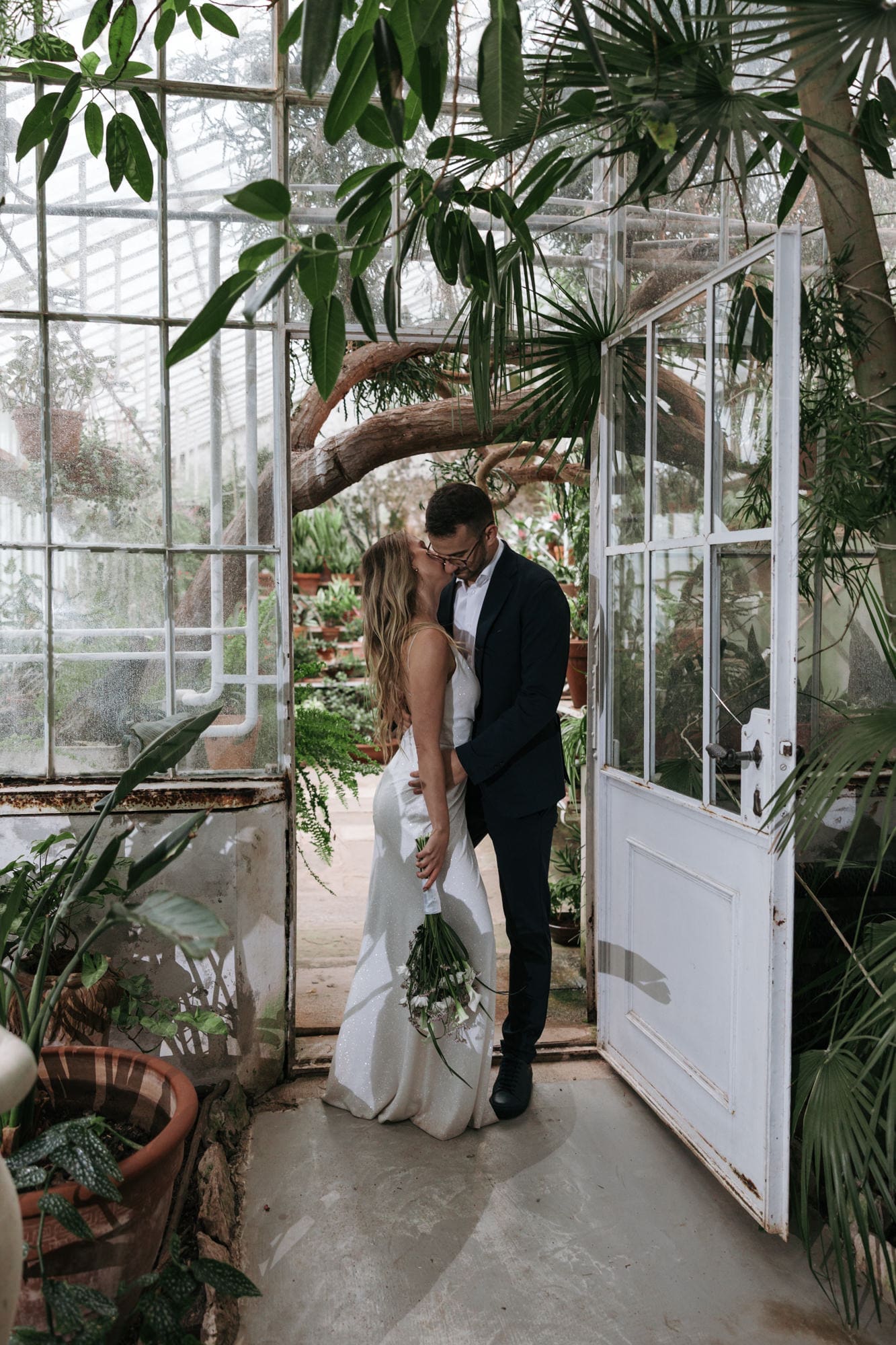 Bride and groom sharing a romantic moment inside the historic greenhouse at Villa Mirasasso near Sežana, Slovenia.